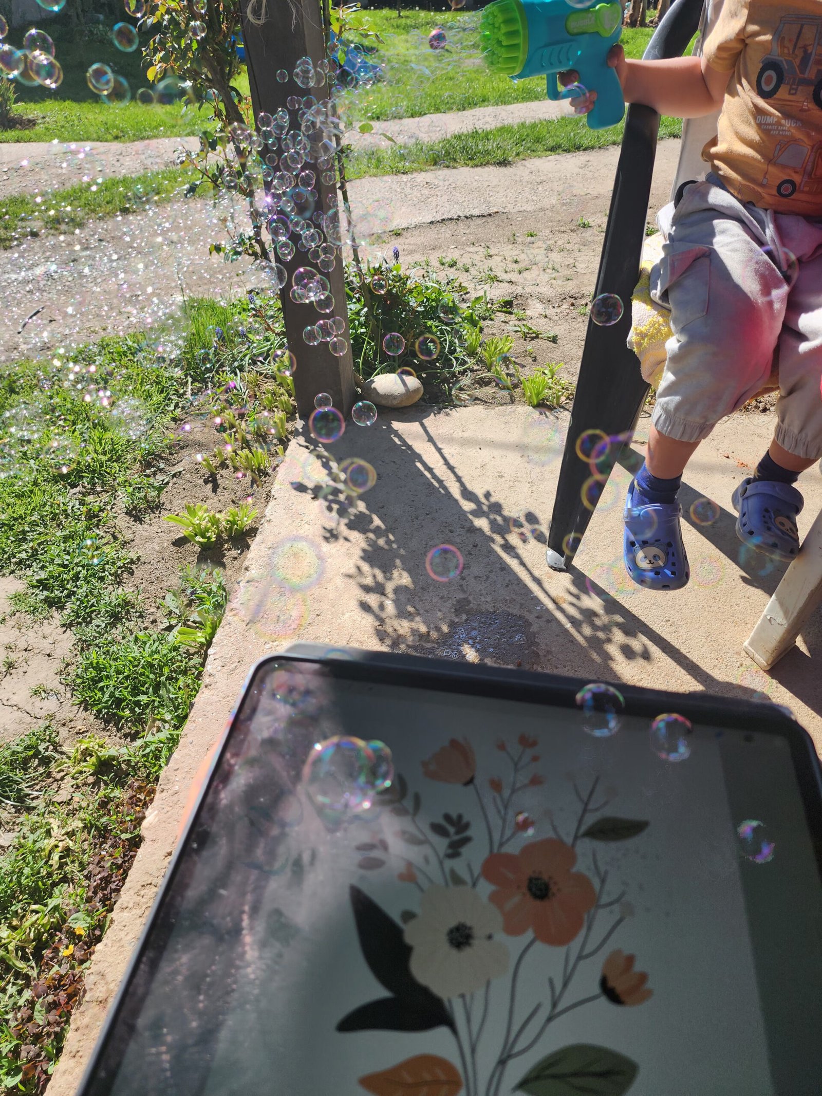 Tablet with a digital drawing resting on a bench, child standing nearby