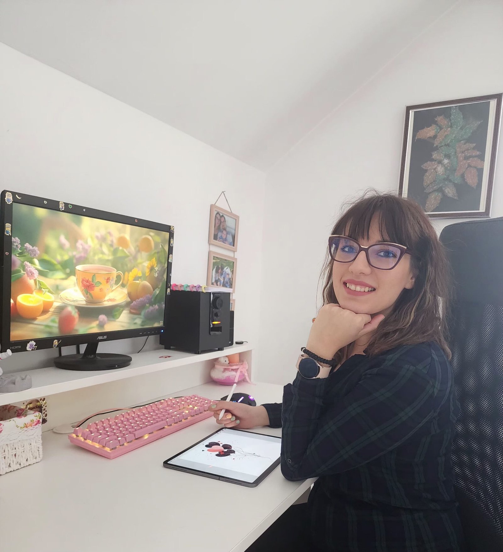 About Me - Milica Dreams-Milica sitting at a cozy pink workspace with a tablet, smiling at her creative desk setup